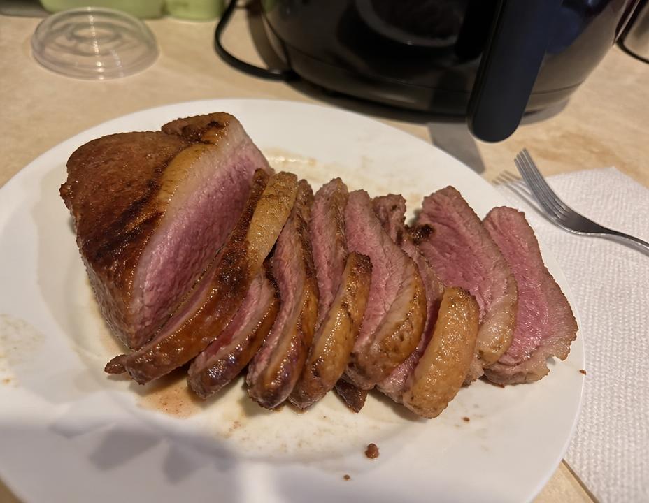 Picanha fatiada em prato branco na bancada da cozinha