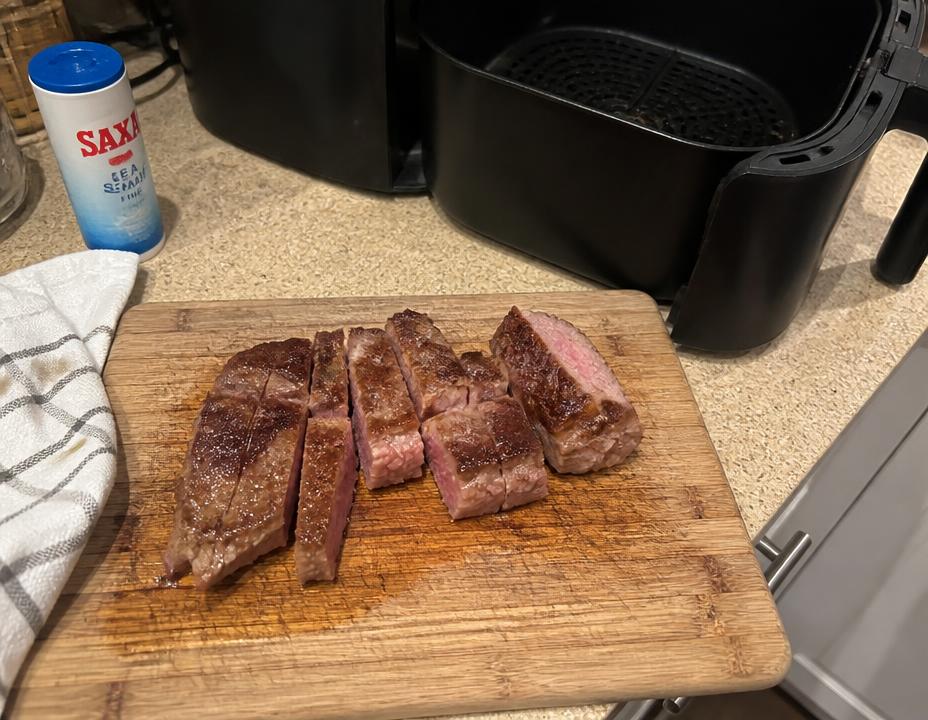 Carne feita na Airfryer fatiada sobre tábua na cozinha
